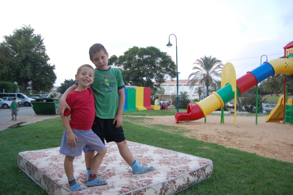 Lads playing in a Sderot playground, in front of the bomb shelter.