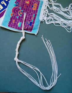 Tzit-tzit on the corner of a prayer shawl - a reminder of the need for righteousness.